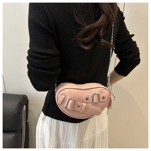 Détail du sac rose en forme de cœur avec boucle argentée et bandoulière en chaîne