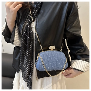 Detail of light blue denim clutch with gold chain strap and crystal-encrusted oval clasp