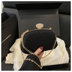 Detailed view of luxury black evening bag with diamond clasp in elegant gift box