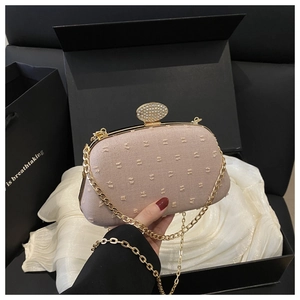 Detail of pink bow-textured evening clutch with sparkling rhinestone clasp and gold chain
