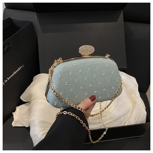 Detail of light blue evening clutch with rhinestone snap closure and gold chain strap