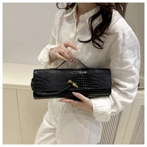 Close-up of black crocodile pattern baguette bag with iconic golden twist metal buckle