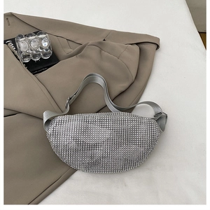 Detail of silver rhinestone crescent bag with adjustable wide fabric strap on blazer