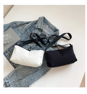 Details minimalistischer Nylon-Umhängetaschen in Schwarz und Weiß mit Trageriemen