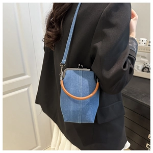 Detail der blauen Denim-Arzttasche mit braunem Rundgriff und silbernem Metallverschluss