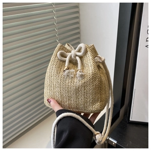Detailed close-up of handmade straw bucket bag with woven texture and cotton rope strap