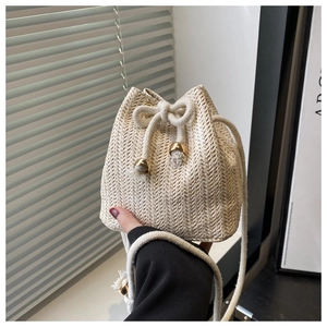 Detail of hand-woven straw bucket bag with wave texture and cotton drawstring closure