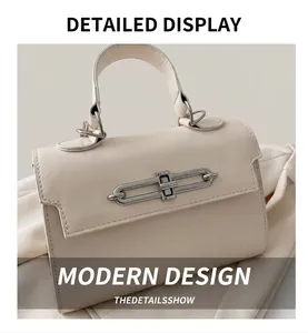 Detail shot of a beige leather handbag featuring a stylish silver metal ring clasp closure