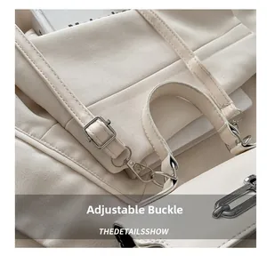 Detail of beige leather handbag showing adjustable silver buckle and handle joint texture