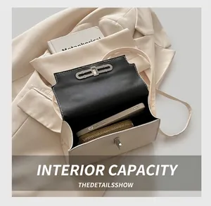 Detail show of small beige crossbody bag capacity with silver twist lock and black interior