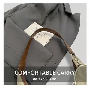 Close-up of brown leather handle and silver metal clasp on canvas tote bag
