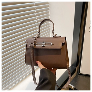 Detailed macro view of the coffee brown matte leather bag with sleek silver metal buckle