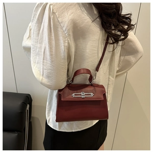 Sac à main en cuir bordeaux foncé avec fermoir argenté et poignée supérieure unique