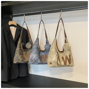 Detail of vintage washed canvas hobo bags in dark grey, denim blue and beige with mini pouch