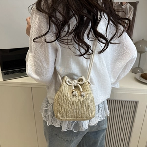 Handcrafted straw bucket bag with drawstring closure and tassel for summer beach vacations