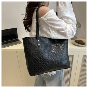 Detail of black woven leather tote bag showing large capacity and soft texture