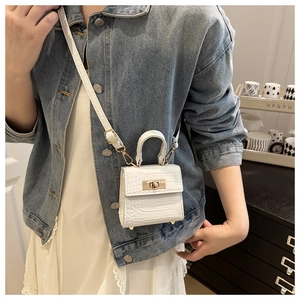 Detail of white crocodile pattern mini bag with metal lock and top handle crossbody style
