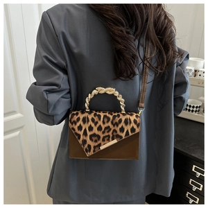 Dettaglio borsa leopardata con manico a serpente dorato e tracolla in pelle color marrone
