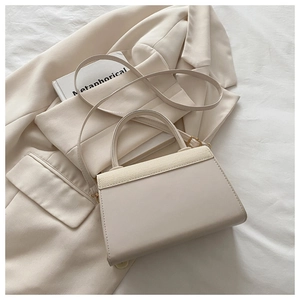 Detail of cream leather and woven texture mix on a structured crossbody handbag