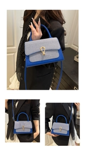 Detail of royal blue handbag with striped fabric inlay and a gold metal twist lock buckle