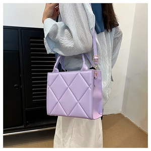 Detail of light purple quilted tote bag with gold hardware and adjustable strap