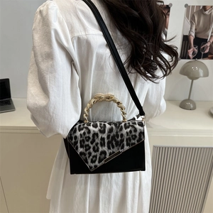 Damentasche mit Leopardenmuster und goldenem Webgriff zu weißem Kleid