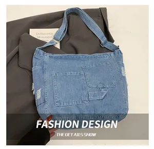 Detail shot of washed blue denim tote bag with front pockets and frayed edge texture