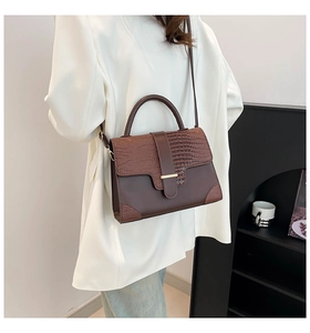 Detailed view of the brown leather texture and crocodile pattern on the vintage handbag