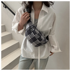 Detailed view of fashionable black and white checkered crossbody bag with adjustable strap