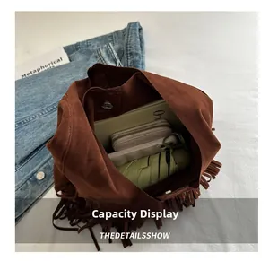 Spacious brown suede tassel shoulder bag showing daily essentials inside for capacity