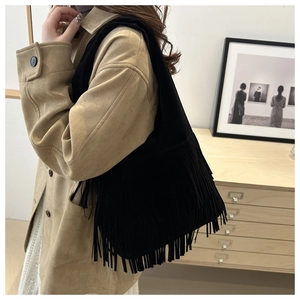 Detail of black suede tassel tote bag showing fringe texture and large capacity side view