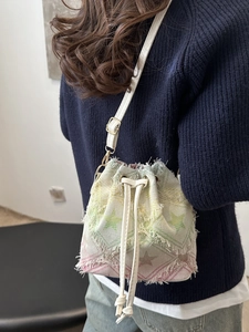Borsa a secchiello in denim a scacchi con stelle sfumate e nappe con frange boho