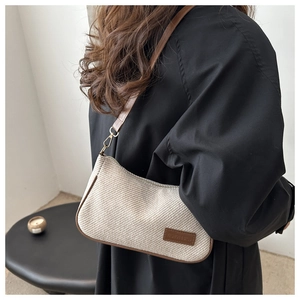 Detail of retro woven shoulder bag with white fabric texture and brown leather trim