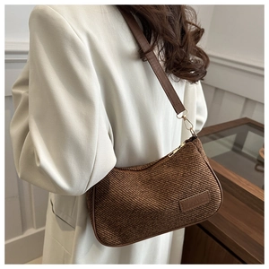 Detail of vintage brown corduroy shoulder bag with leather label and gold zipper