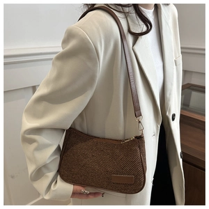 Close-up of vintage brown woven hobo bag with leather strap and half-moon design