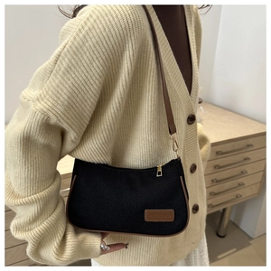 Detail of vintage black corduroy underarm bag with brown faux leather trim and gold zipper
