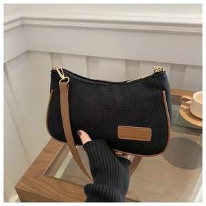 Detail of vintage black fabric shoulder bag with brown leather trim and metal zipper