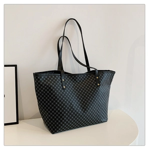 Detail view of large black tote bag with geometric dotted pattern and gold rivets