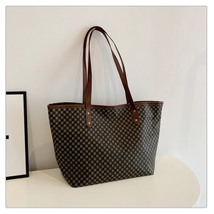 Detail of vintage tote bag with geometric print, leather handles and gold rivet accents