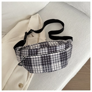 Detail of black and white checkered corduroy waist bag with adjustable nylon strap