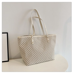 Detailed view of large tote bag with geometric grid pattern and sturdy white handles
