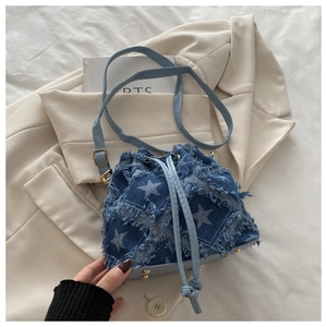 Detail of star pattern denim bucket bag with frayed edges and drawstring closure