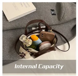 Detailed interior of a beige crossbody tote showing items like a phone and perfume