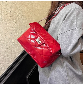 Détail du sac bandoulière matelassé rouge avec fermoir argenté et bandoulière chaîne