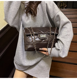 Détail du sac matelassé marron avec fermoir rotatif argenté et bandoulière chaîne