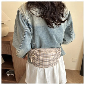 Close-up of retro plaid waist bag with adjustable strap and silver metal zipper details