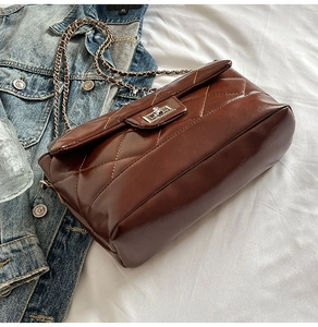 Vue de dessus d'un sac bandoulière marron foncé matelassé avec chaîne argentée et fermoir