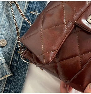 Gros plan d'un sac matelassé marron avec cuir brillant vintage et bandoulière chaîne