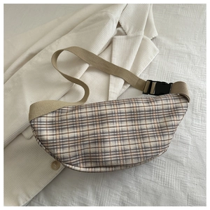 Vue à plat d'un sac bandoulière à carreaux sur un blazer en velours côtelé chic