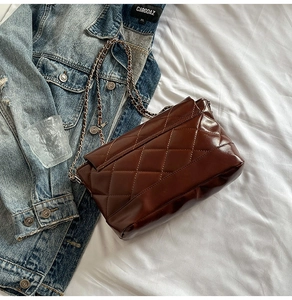 Détail du sac bandoulière matelassé marron foncé en cuir ciré brillant avec chaîne